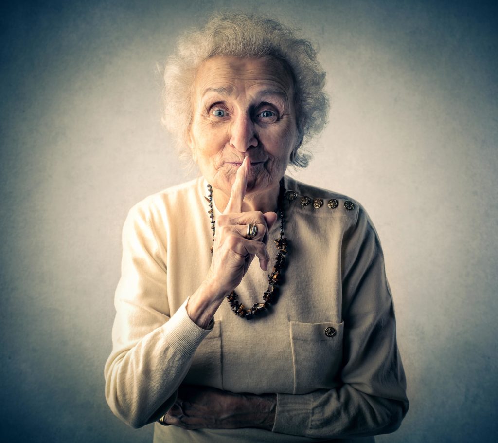 Close-up portret van oudere dame met de vinger op de lippen